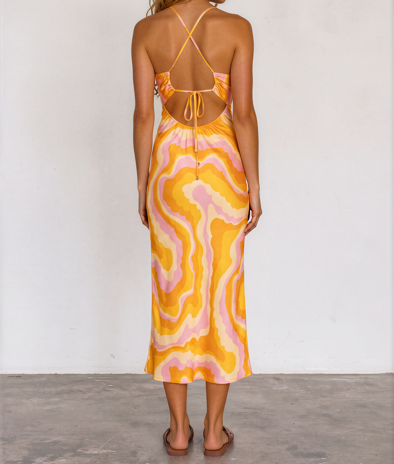 Back view of model wearing the Suboo Cloud Keyhole Dress, showing the open tie back, the retro swirl pattern in pink, orange, yellow and beige
