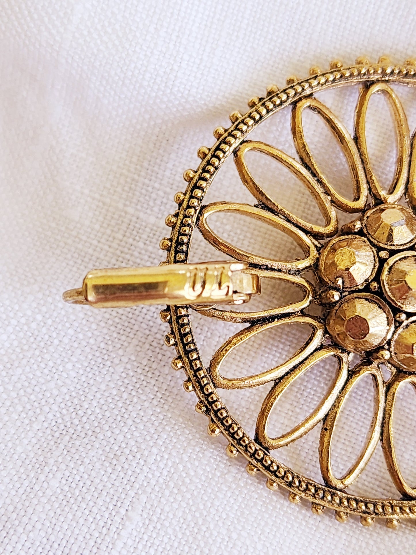 Back view of the Sunflare earrings showing the clasp the U L initials and gold-tone finish.