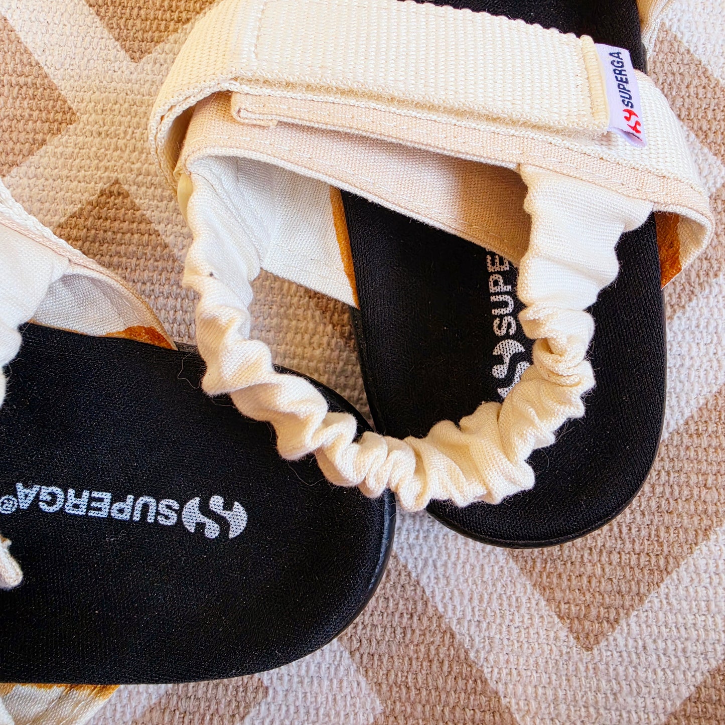 Detail of the back strap on Superga canvas sandals and the brand name on the footbed