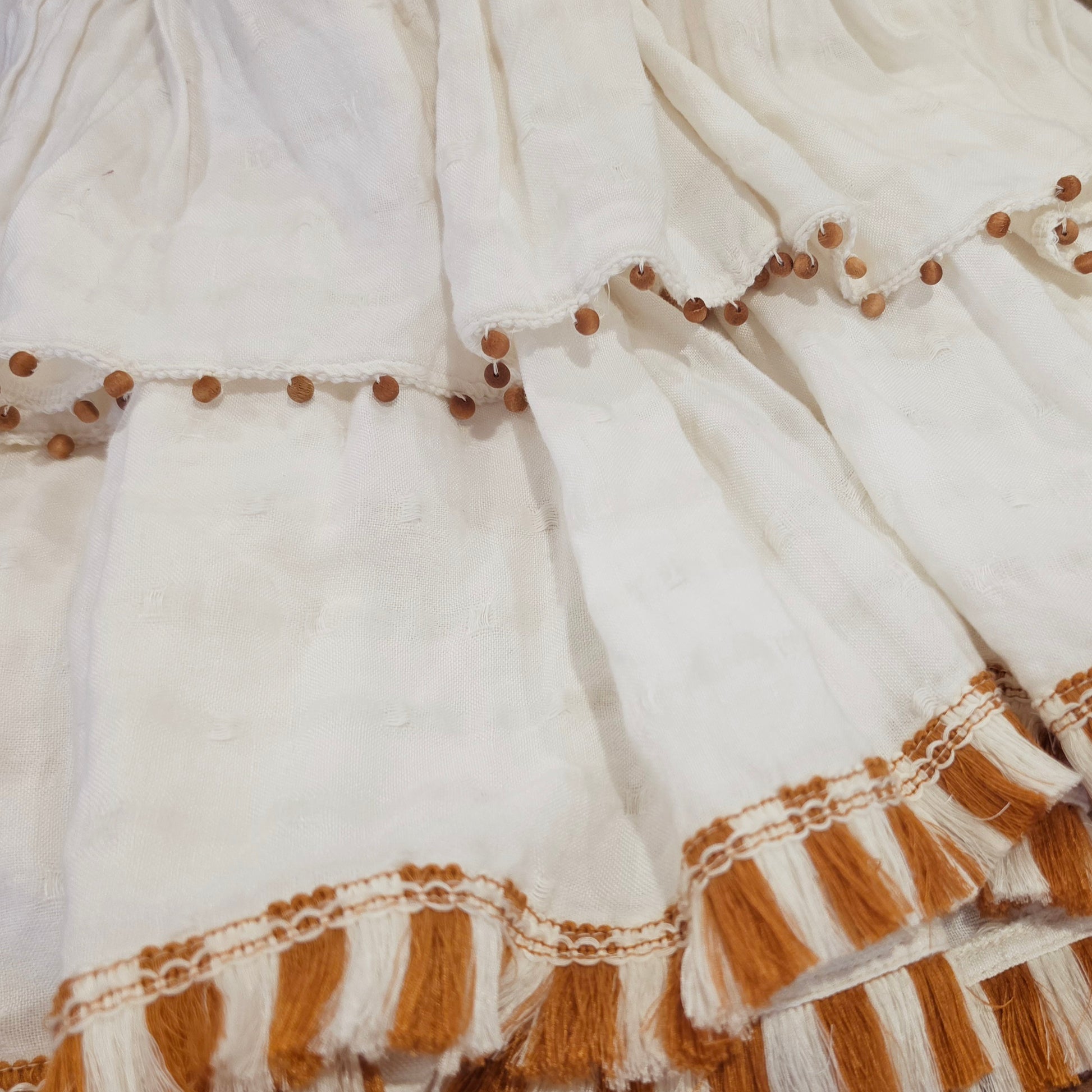 Close up view of the tiered hemline showing the beaded and fronge details.