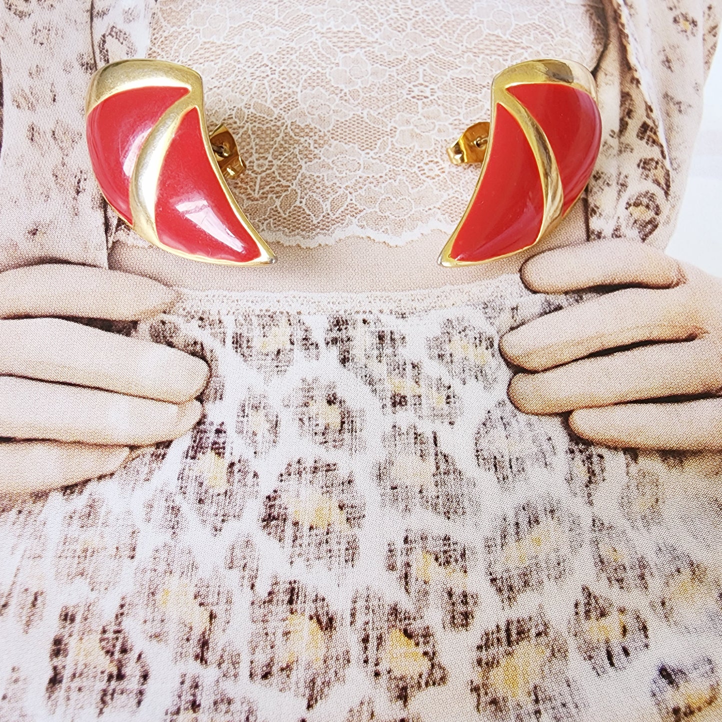 Close view of the vintage barcs enamel earrings, showing the vibrant red and slight surface rubbing.