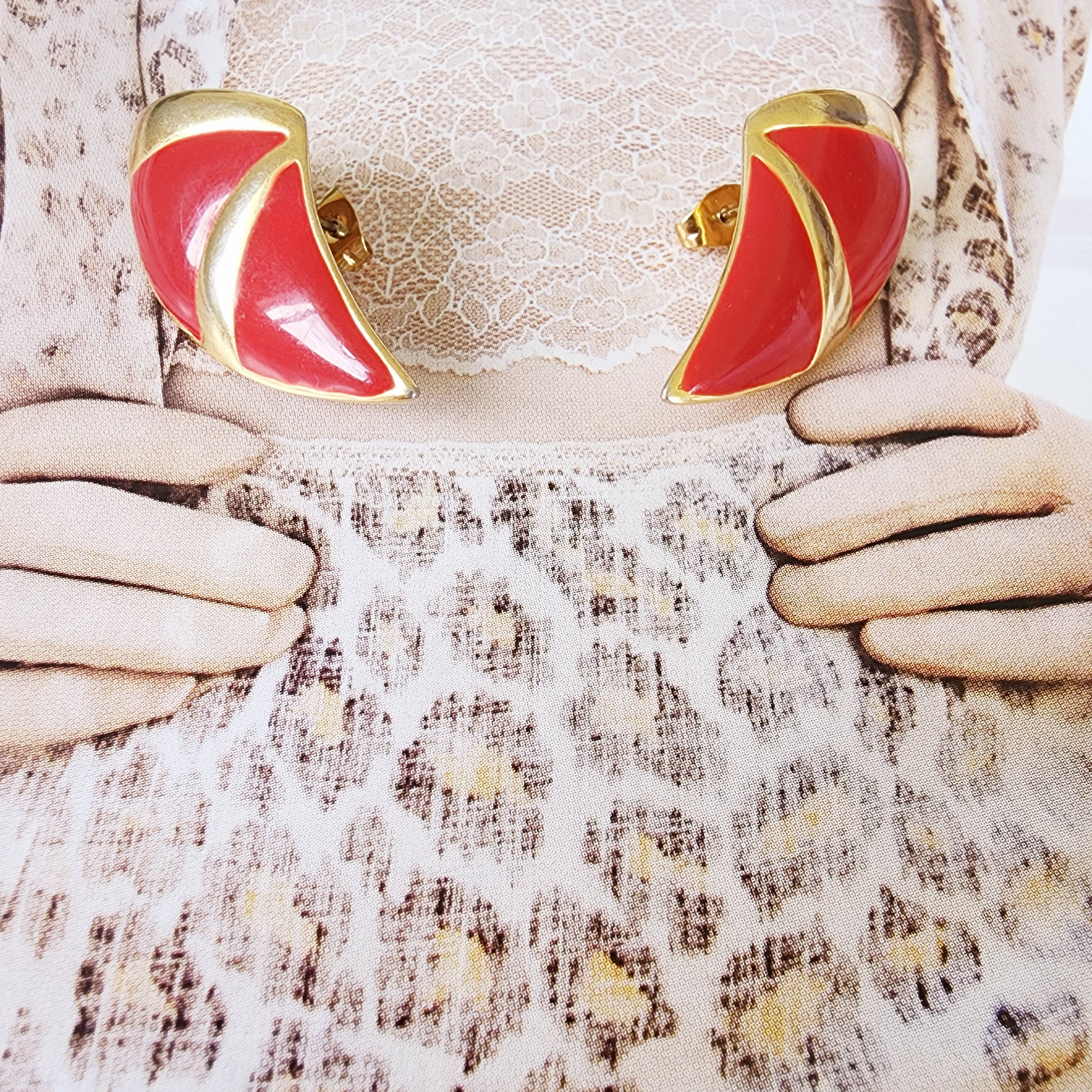 Close view of the vintage barcs enamel earrings, showing the vibrant red and slight surface rubbing.