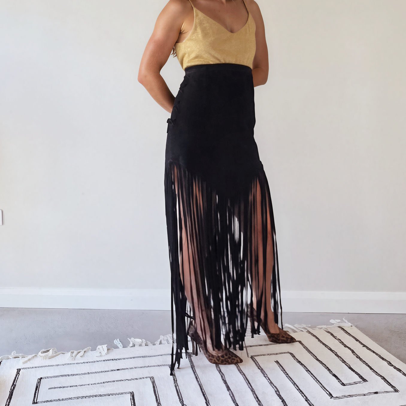 Side view of the vintage long fringe suede skirt with tie side detail, showing the V style hem falling into ankle length fringe.