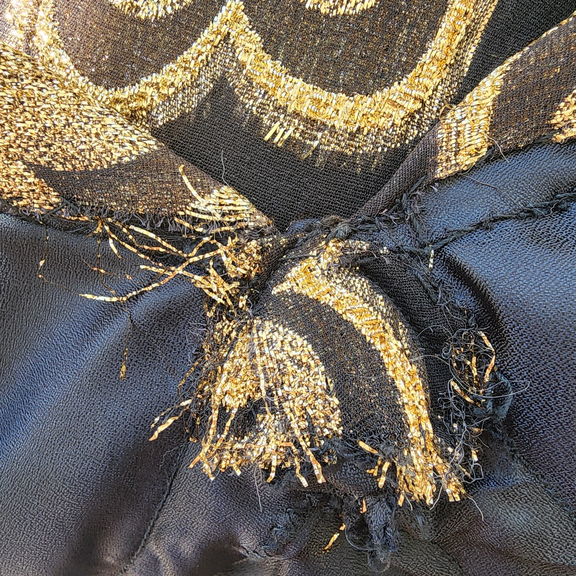 Detail shot of the bust area showing internal fraying in the gold thread at the seam—imperfection not visible when worn