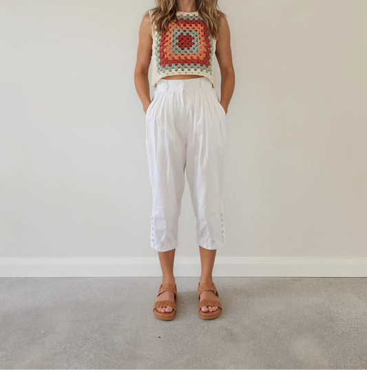 Front view of vintage Katies white cropped high-waisted pants with pleated waist and covered button cuff detail.