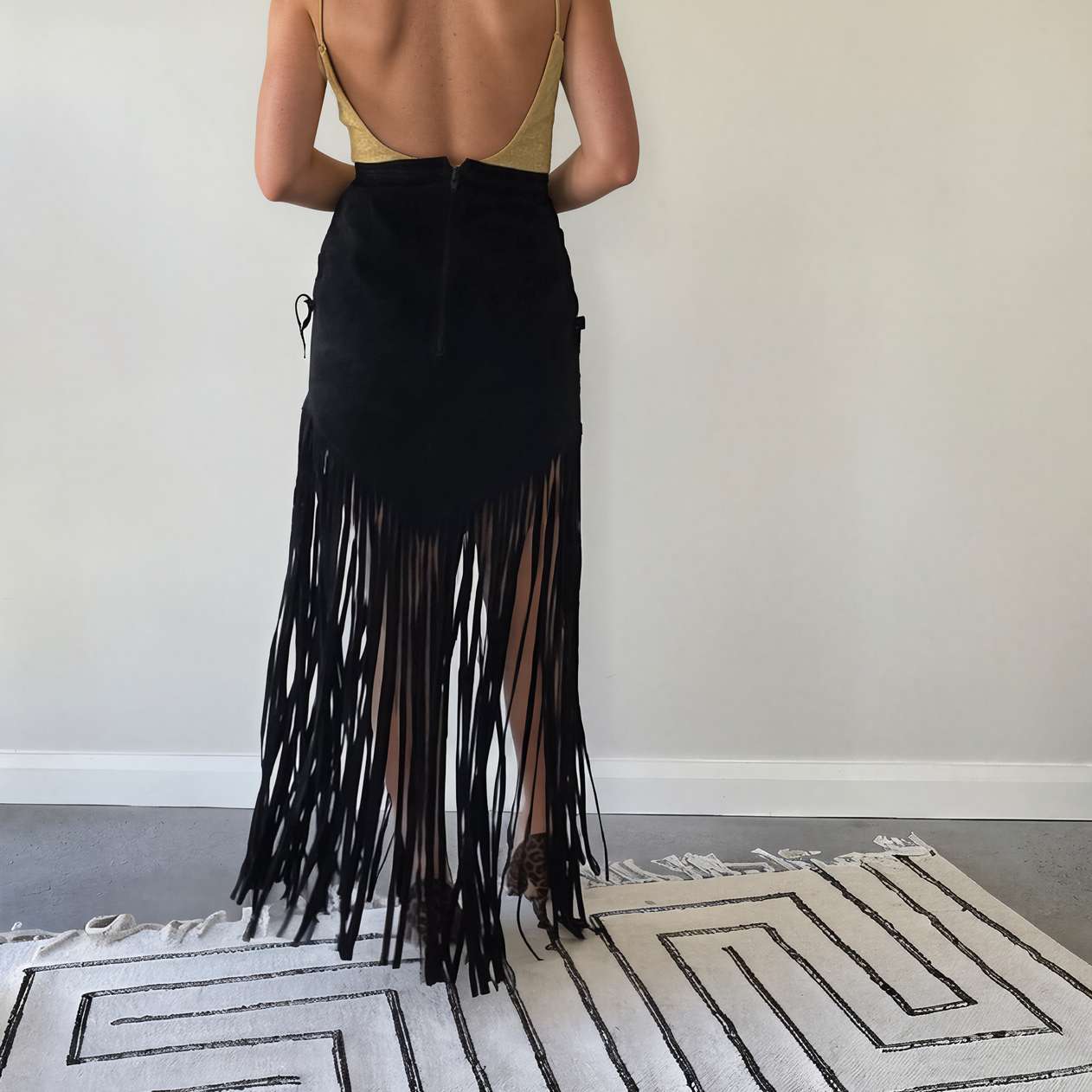 Back view of the vintage long fringe suede skirt with tie side detail, showing the V style hem falling into ankle length fringe.