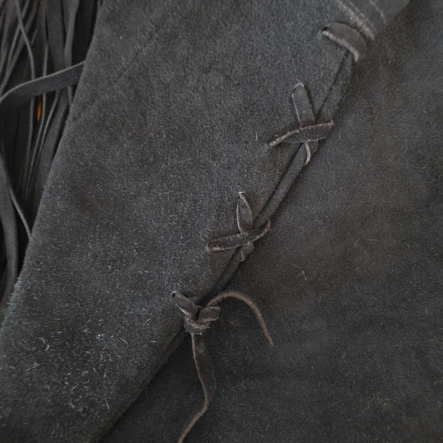 Close up of the side ties and wear on the vintage suede fringe skirt.