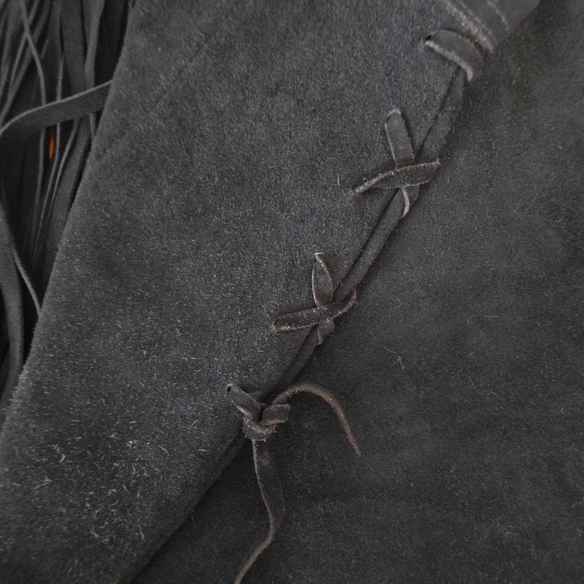 Close up of the side ties and wear on the vintage suede fringe skirt.