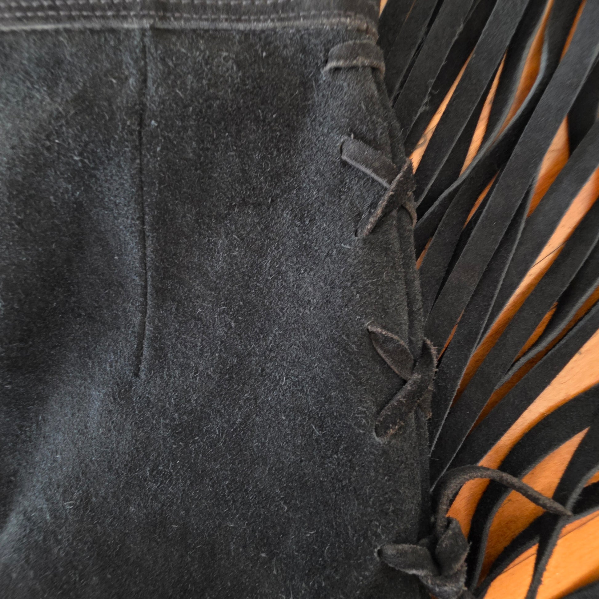 Close up view of the side cross ties and fringe on the vintage suede genuine leather skirt