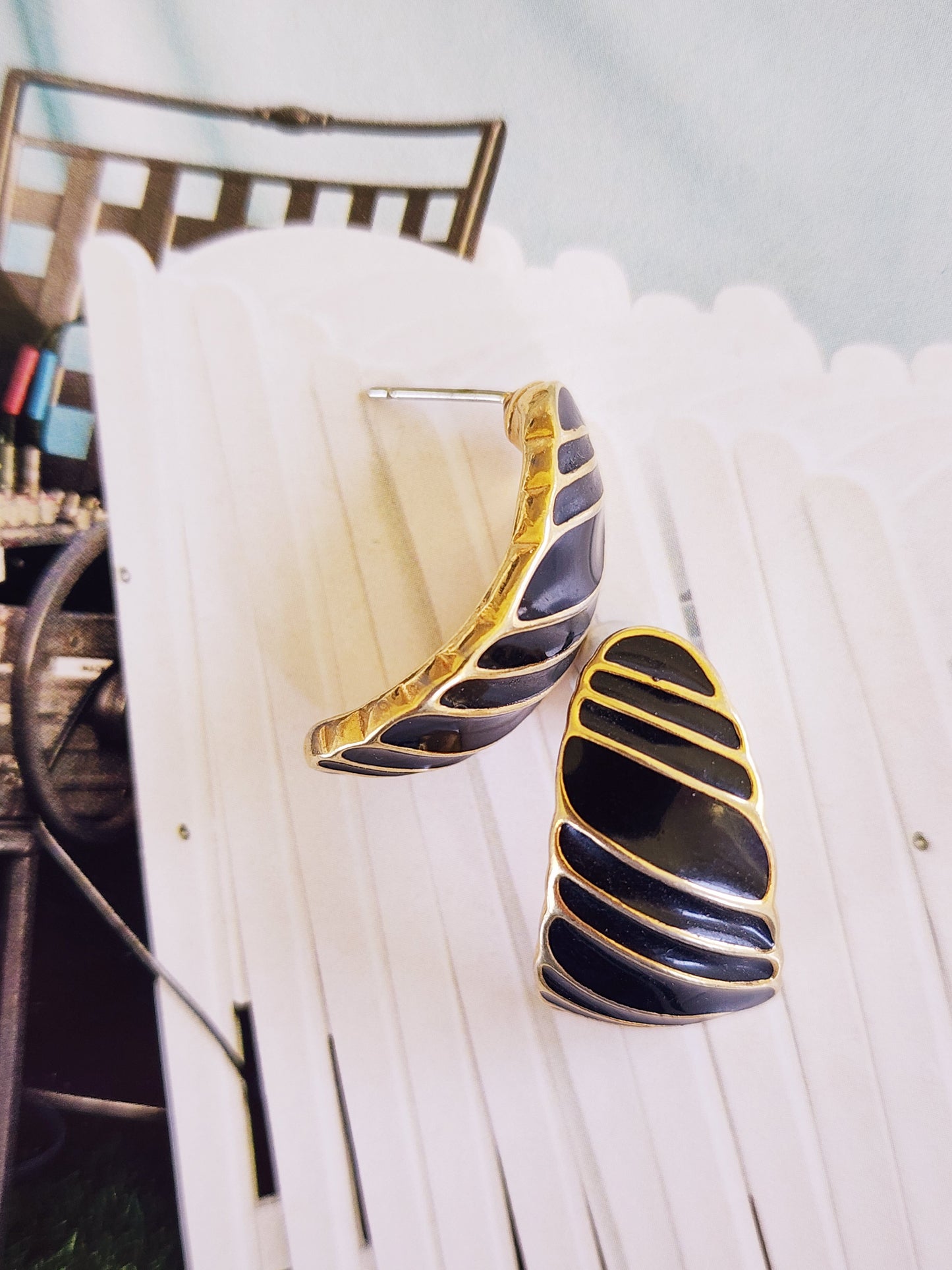 Close up image of the vintage Trifari gold and black stripe enamel earrings.