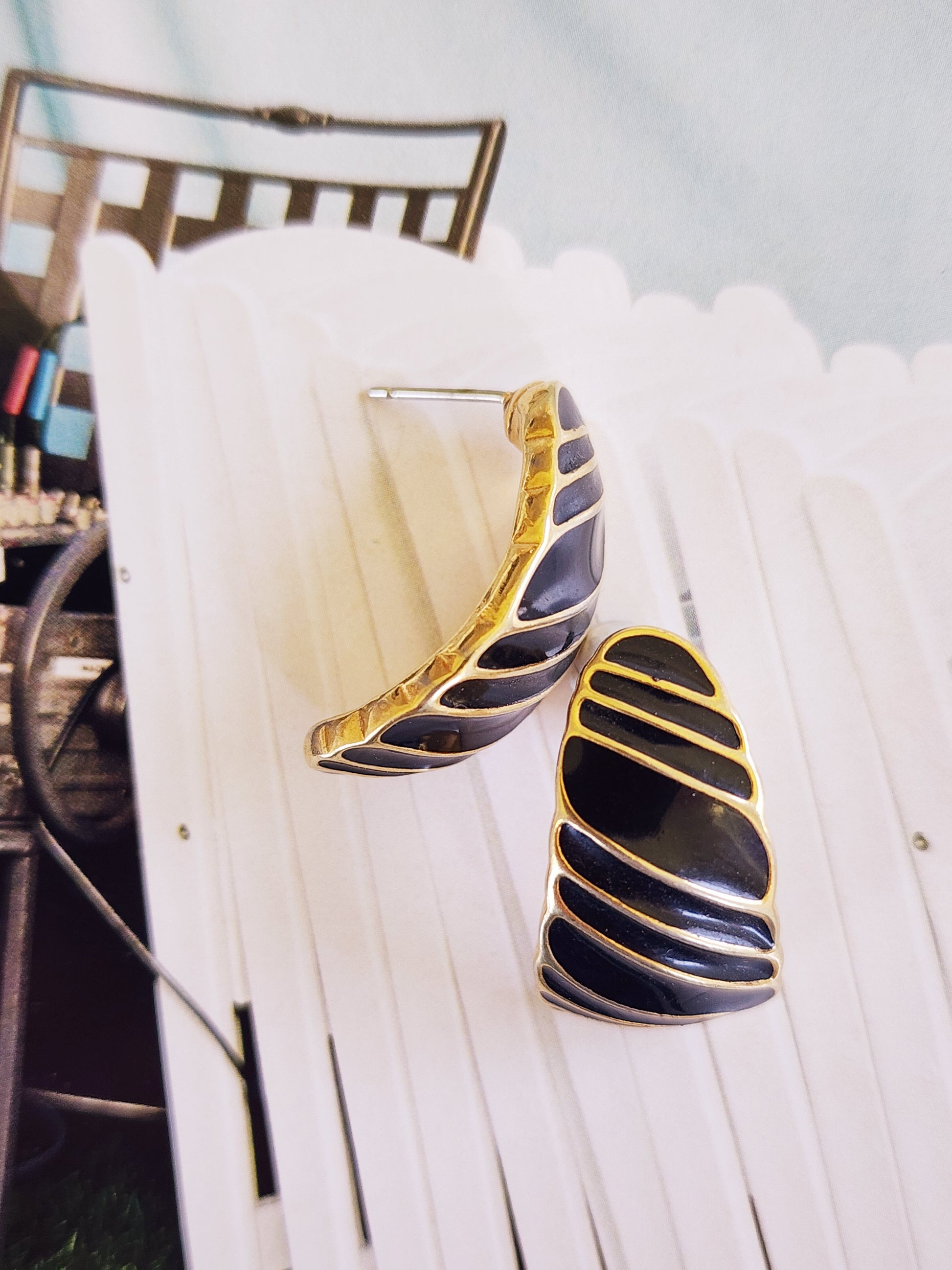 Close up image of the vintage Trifari gold and black stripe enamel earrings.