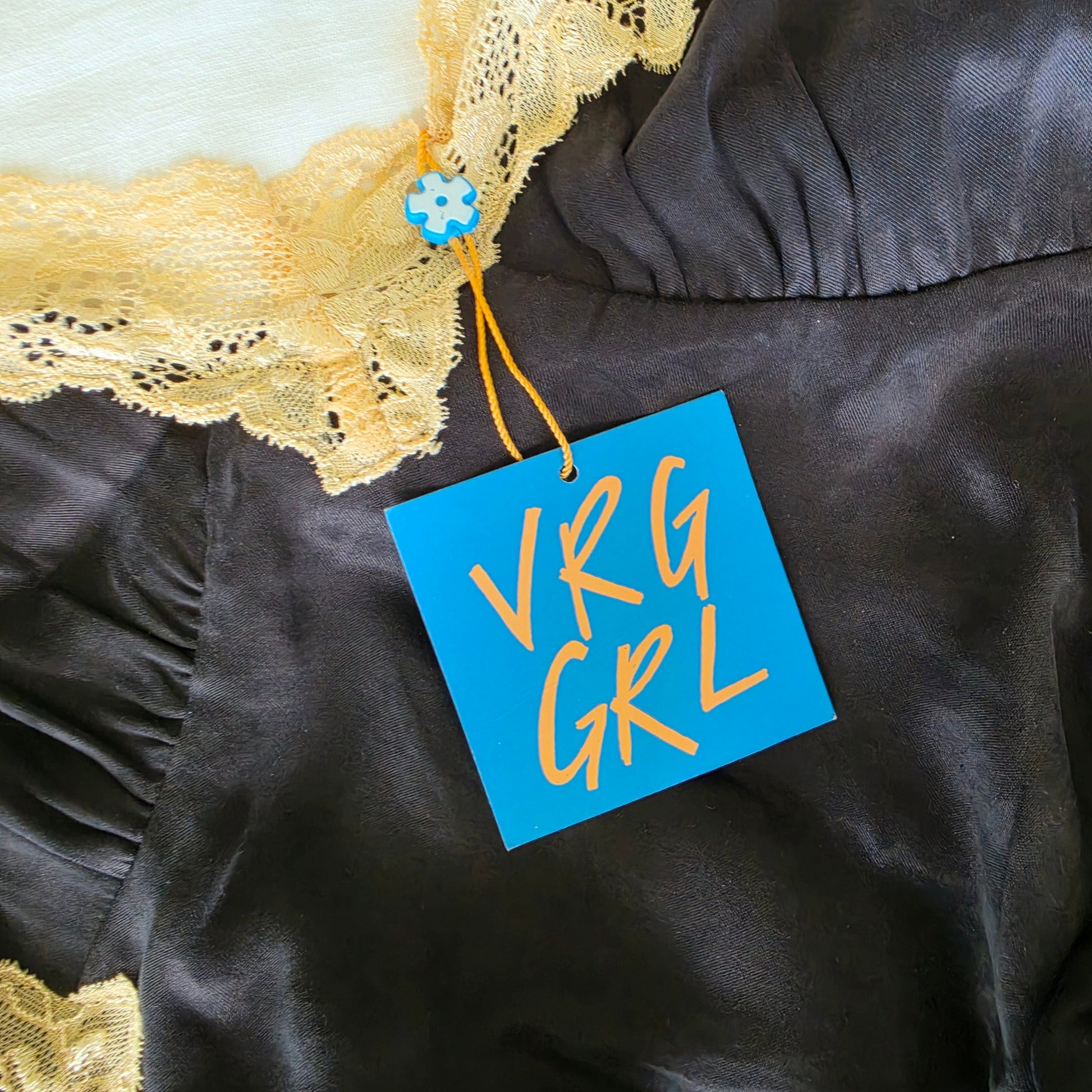 close up view of the swing tag on the Verge Girl mini slip dress