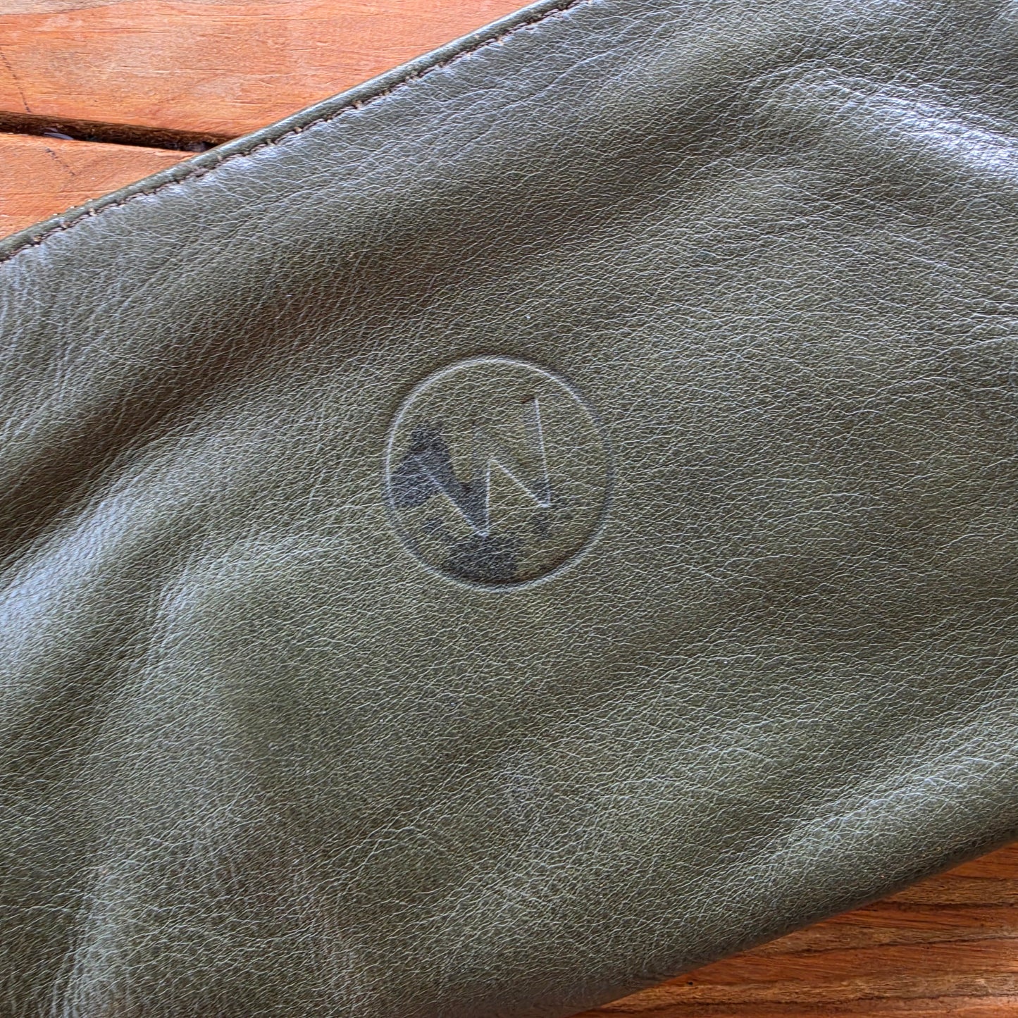 Close-up of wear and markings on olive leather Wanderers wallet