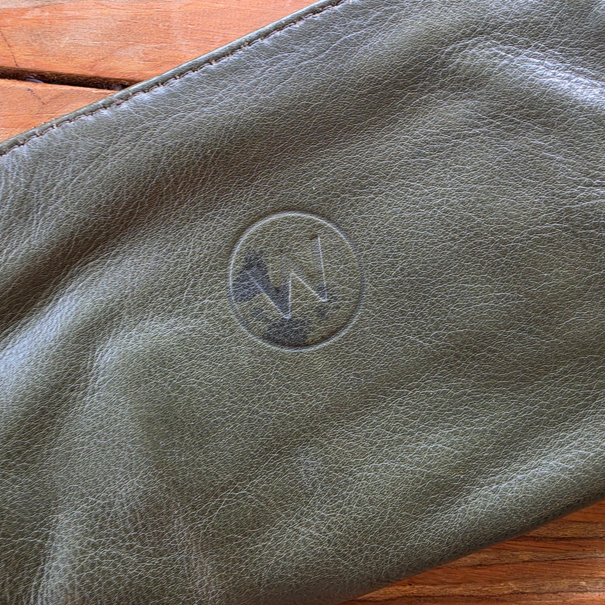 Close-up of wear and markings on olive leather Wanderers wallet